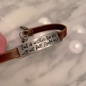 God is within her leather bracelet